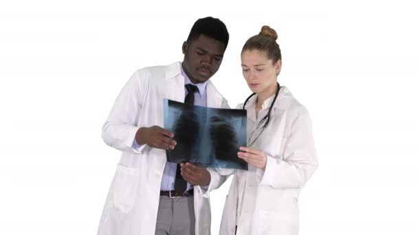 Νεαρή γυναίκα γιατρό και afro Αμερικανός γιατρός, κοιτάζοντας την εικόνα ακτινογραφία των πνευμόνων σε λευκό φόντο. — Αρχείο Βίντεο