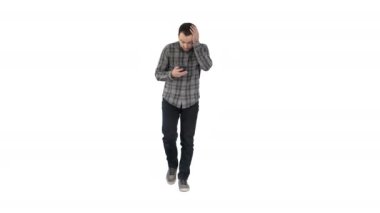 Shoked genç adam beyaz arka plan üzerinde yürürken telefon ve okuma iletisi tutan.