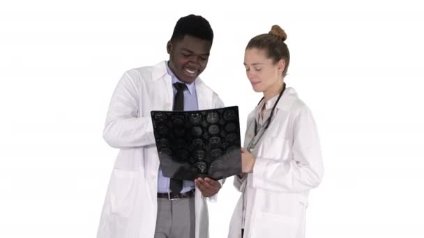 Médicos sonrientes estudiando rayos X sobre fondo blanco. — Vídeos de Stock