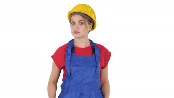 Femme en tenue de construction parler à la caméra tout en marchant sur fond blanc . — Video