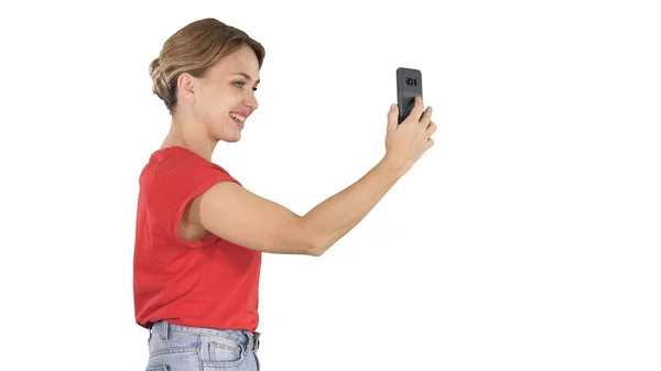 Schöne junge Frau zu Fuß und hält ein Smartphone hoch, um Fotos und Selfies auf weißem Hintergrund zu machen. — Stockfoto