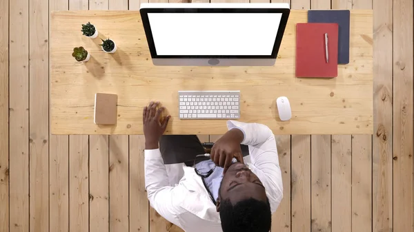 Médico africano viendo algo en la pantalla de la computadora. Pantalla blanca . — Foto de Stock
