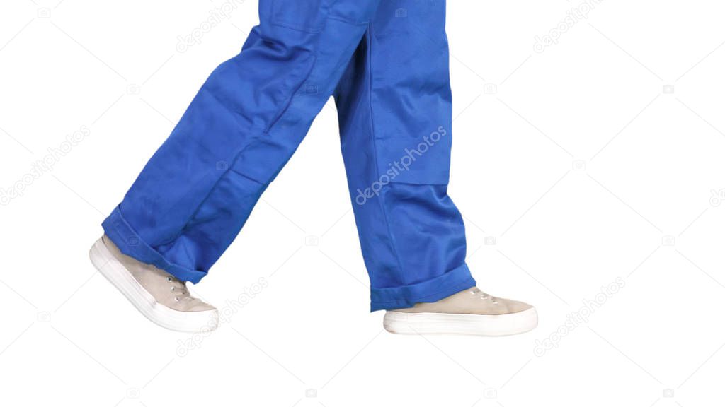 Legs of woman construction worker walking on white background.
