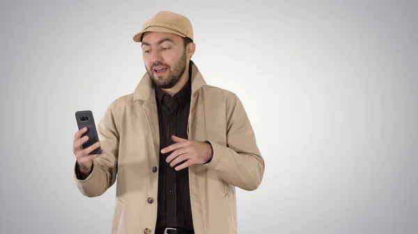 Ung man gör ett videosamtal från sin mobiltelefon när du går på lutning bakgrund. — Stockfoto