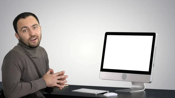 Casual hombre de negocios sonriendo y hablando a la cámara que muestra algo en el monitor de la computadora en el fondo gradiente . —  Fotos de Stock