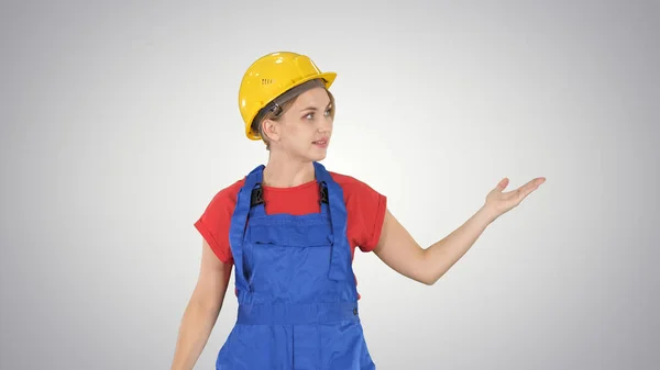 Lachende werknemers jongedame praten en tonen bezwaar maakt tegen haar zijden op de achtergrond met kleurovergang. — Stockfoto