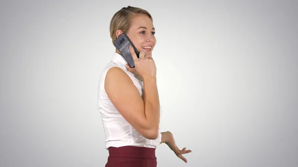 Профессиональная деловая женщина улыбается с мобильным телефоном разговаривая на градиентном фоне . — стоковое фото