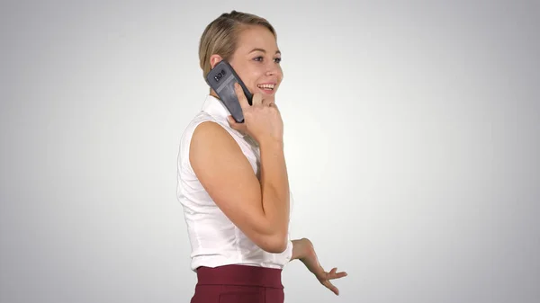 Profissional mulher de negócios sorrindo com telefone celular falando em fundo gradiente . — Fotografia de Stock