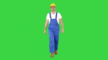 Yeşil Ekranda sarı kasklı yürüyen işçi, Chroma Key.