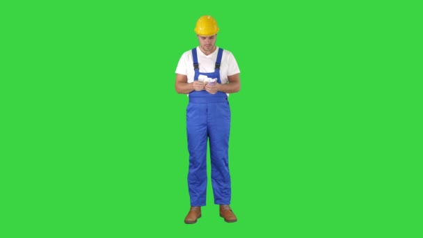 Builder comptant l'argent debout sur un écran vert, Chroma Key . — Video