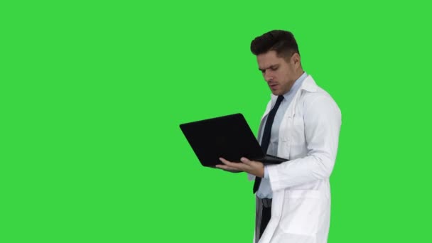 Cheerfull лікар з ноутбуком сміятися після даючи серйозний вигляд на камеру на зеленому екрані, кольоровості ключ. — стокове відео