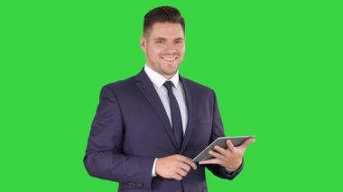 Tablet ile etkileyici genç işadamı yeşil ekranda bir şey swiping sunan, Chroma Anahtar.