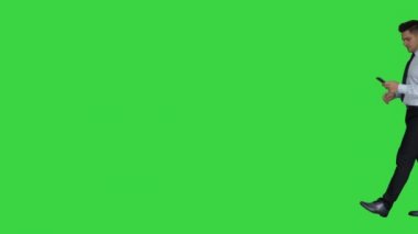 Mutlu iş adamı cep telefonu kullanarak çerçeve içinde yürüyüş ve daha sonra yeşil ekranda çıkış kazanan jest yapma, Chroma Key.
