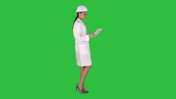 Mladá žena inženýr chodit s tabletem na zelené obrazovce, Chroma Key při pohledu na objekty v okolí. — Stock video