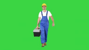 Yeşil Ekranda alet kutusu ile yürüyüş inşaat işçisi, Chroma Anahtar.