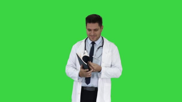 Врач читает медицинский отчет пациента или рецепт или учебник на зеленом экране, хрома ключ . — стоковое видео