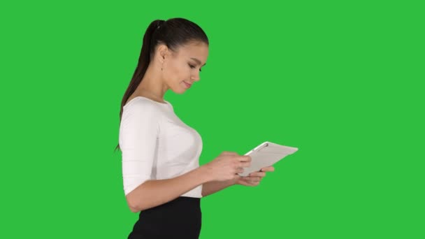 緑の画面上のタブレットでゲームを楽しんで楽しんでいる美しい若い大人の女性, クロマキー. — ストック動画