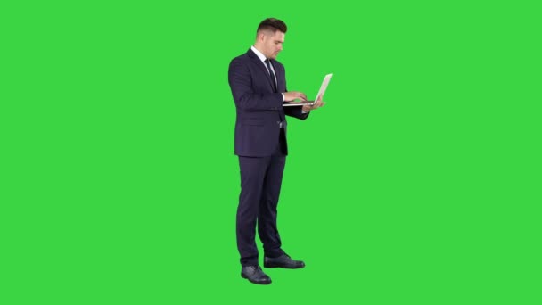 Geschäftsmann stehend und mit Laptop auf einem grünen Bildschirm, Chroma-Taste. — Stockvideo