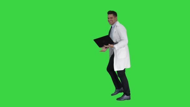 Entreprenör ingenjör eller läkare med en bärbar dator skrattar på en grön skärm, Chroma Key. — Stockvideo