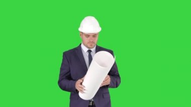 Profesyonel mimar yürüyor ve plan tutuyor adam Yeşil Ekranda kask takıyor, Chroma Key.