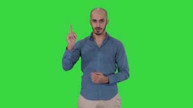 Bir Yeşil Ekran, Chroma Key üzerinde dikkat jest parmak yapma rahat Arap adam.