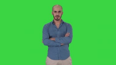 Rahat kıvrımlar ciddi kendinden emin arap adam Yeşil Ekranda kameraya bakarak eller, Chroma Key.