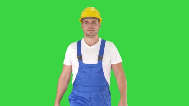 Walking worker in yellow helmet on a Green Screen, Chroma Key. — Stock Video