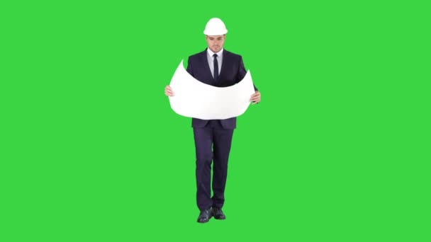 Arquitecto profesional está caminando y sosteniendo el plano El hombre está usando casco en una pantalla verde, Chroma Key . — Vídeo de stock