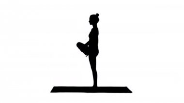 Siluet Genç çekici kadın yoga yoga ağaç egzersiz yapıyor.