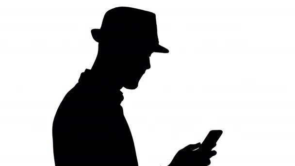 Silueta Hombre casual mensajes de texto en el teléfono y caminar. — Vídeos de Stock