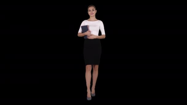 노트를 가지고 걷고 있는 아름다운 아가씨 알파 채널 — 비디오