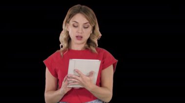 Elinde tablet tutan kırmızı tişörtlü bir kadın ciddi bir yüzle Alfa Kanalı 'na konuşuyor.