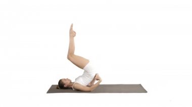 Yoga yapan, salamba sarvangasana egzersizinde duran bir kadın beyaz arka planda omuz duruşunu destekledi..