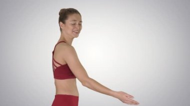 Sportif fitness sporcusu kollarını germe ve degrade arka planda gülüyor.