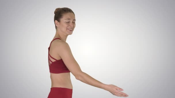 Спортивная спортсменка, растягивающая руки и смеющаяся на градиентном фоне . — стоковое видео