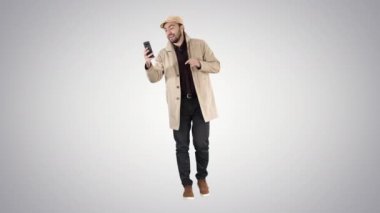 Sonbahar moda tarzı adam kayıt video blog gradyan arka planda yürüyüş.