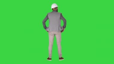 Mühendis ayakta ve Yeşil Ekran, Chroma Key etrafında bakıyor.