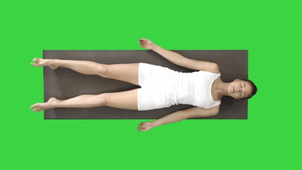 Yoga meditasyonu, yeşil ekranda kapalı gözlerle bir paspasın üzerinde yatıyor, Chroma Key. — Stok video