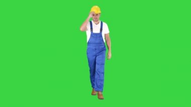 İnşaat işçisi yürüyüş ve yeşil ekranda sert şapka veya kask koyarak, Chroma Anahtar.