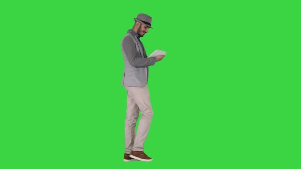 Homem casual usando tablet e sorrindo enquanto acorda em uma tela verde, Chroma Key . — Vídeo de Stock