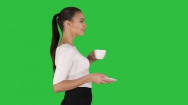 Çay ya da kahve Chroma anahtar yeşil ekran yürüyüş ile beyaz kupa ile güzel esmer kadın.