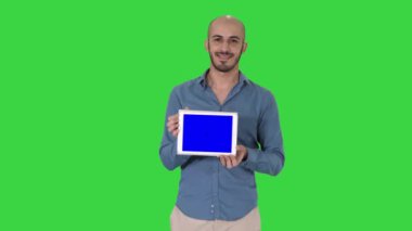 Arap adam yürüyüş ve yeşil ekranda bir şey sunan tablet gösteren, Chroma Anahtar.