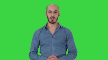 Gömlek Arap genç adam bir şey sunan konuşan ve Yeşil Ekran, Chroma Key üzerinde yan işaret.