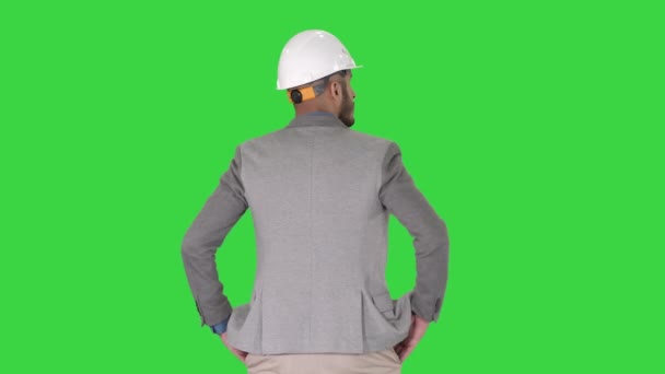 Μηχανικός στέκεται και κοιτάζοντας γύρω σε μια πράσινη οθόνη, πλήκτρο αποχρώσεων. — Αρχείο Βίντεο