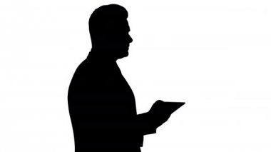 Silhouette genç işadamı dokunmadan dijital tablet ve kontrol nesne onun önünde.