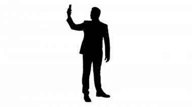 Onun telefon ile Silhouette mutlu genç yakışıklı işadamı kayıt vlog.