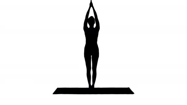 Silueta Atraktivní dívka stojící v rovnováze jógy představují Garudasana. Mladá žena v orlí józe pózuje. — Stock video