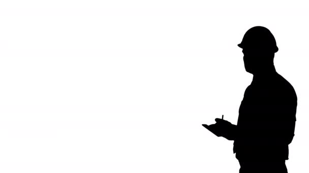 Silhouette Man in helmet and formal clothes walking looking around and making notes. — Stock Video