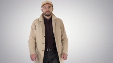 Degrade arka planda yürüyen trençkot koyu sakallı moda adam.
