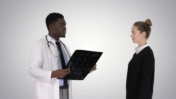 Physician showing a patient the X-ray results Then patient leaves on gradient background. — Stock Video